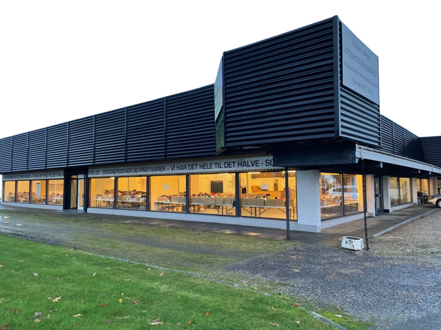 Moderne sort butik med store vinduer og belysning